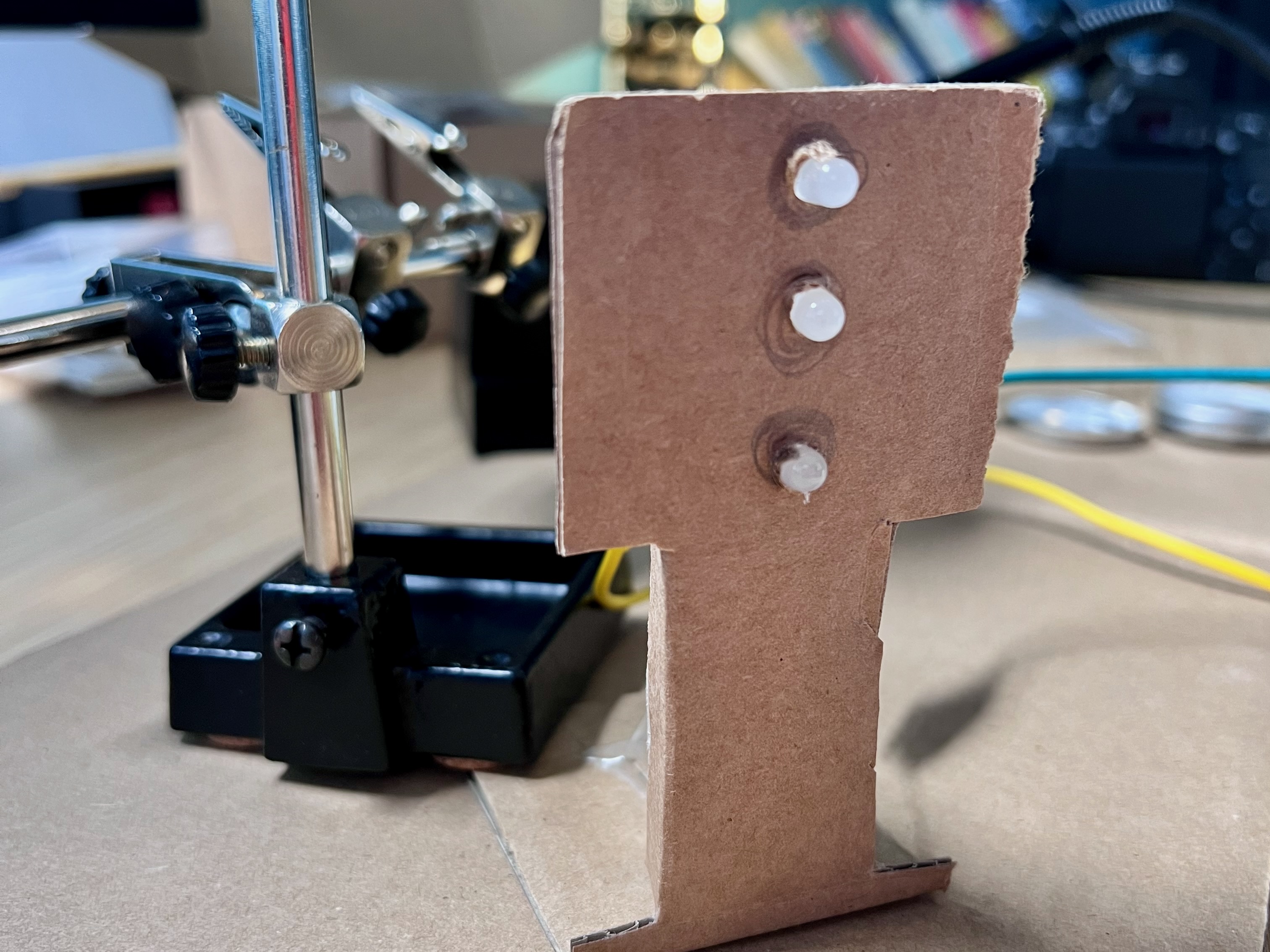 Photo showing a carboard model of a traffic light with three LEDs for the red, amber and green lights. All the LEDs are off.