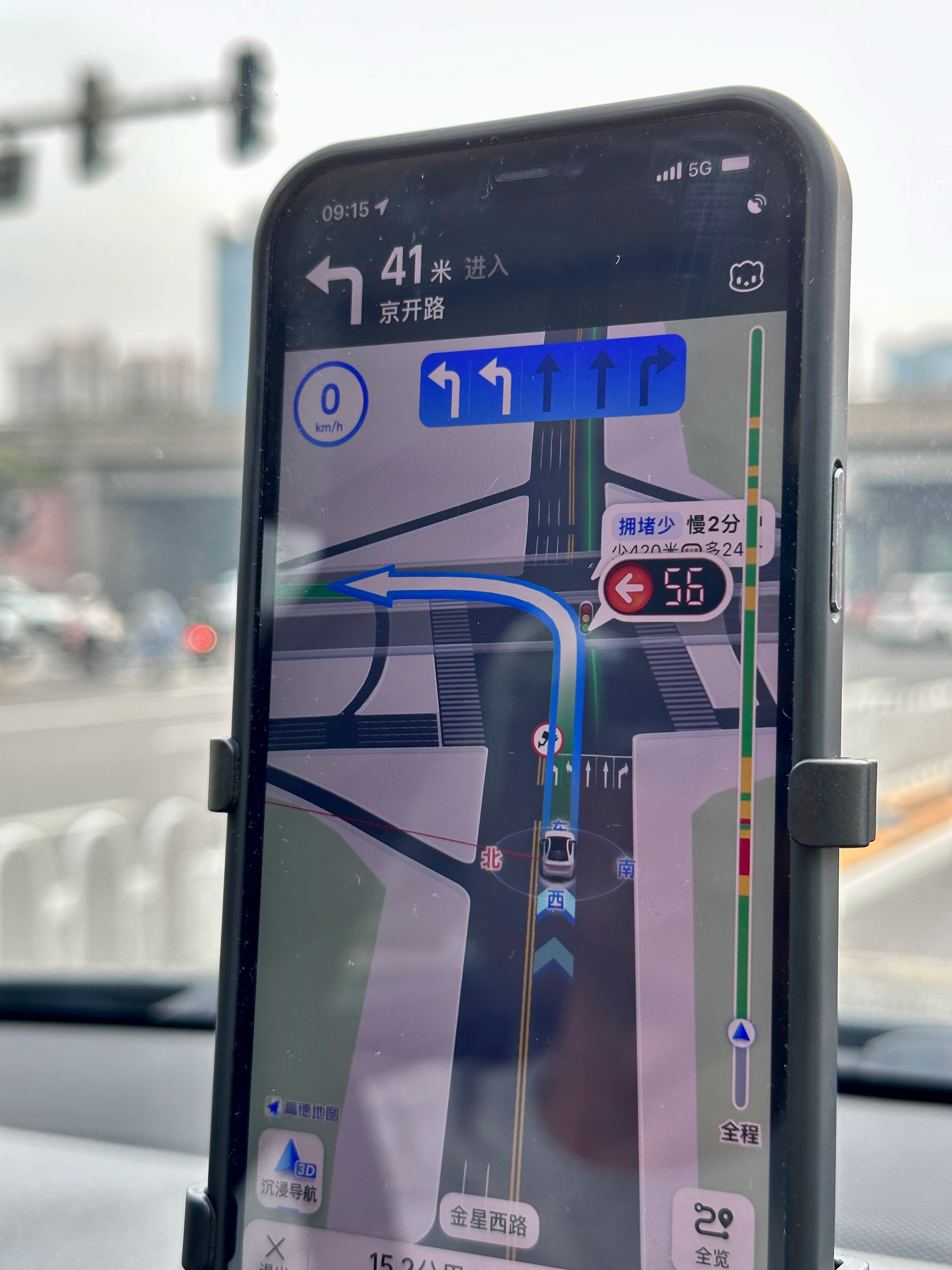 Photo of a phone showing a navigation app in China. The app is suggesting a left turn and shows that there are 56 seconds left on the red light.