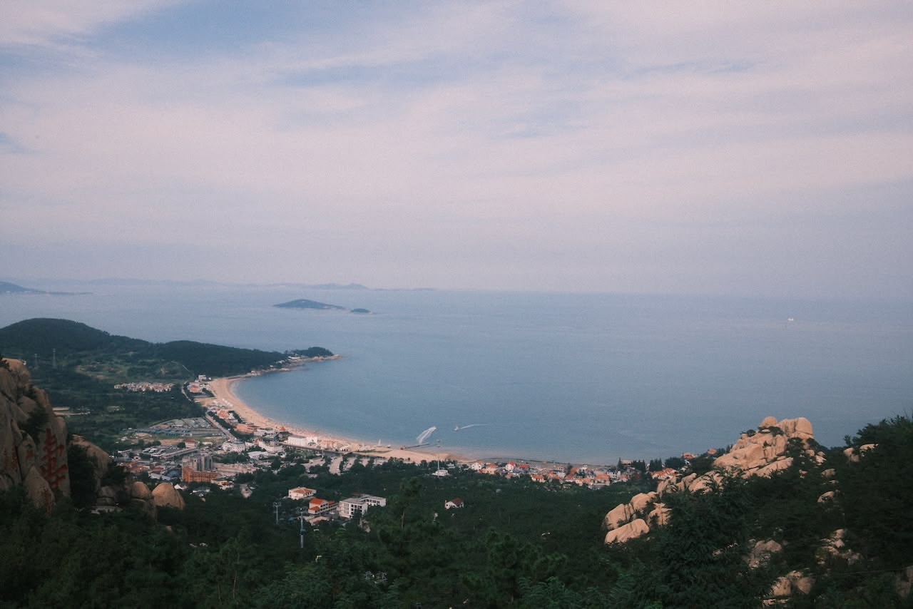 A colour photograph taken from the top of a mountain looking out over a bay