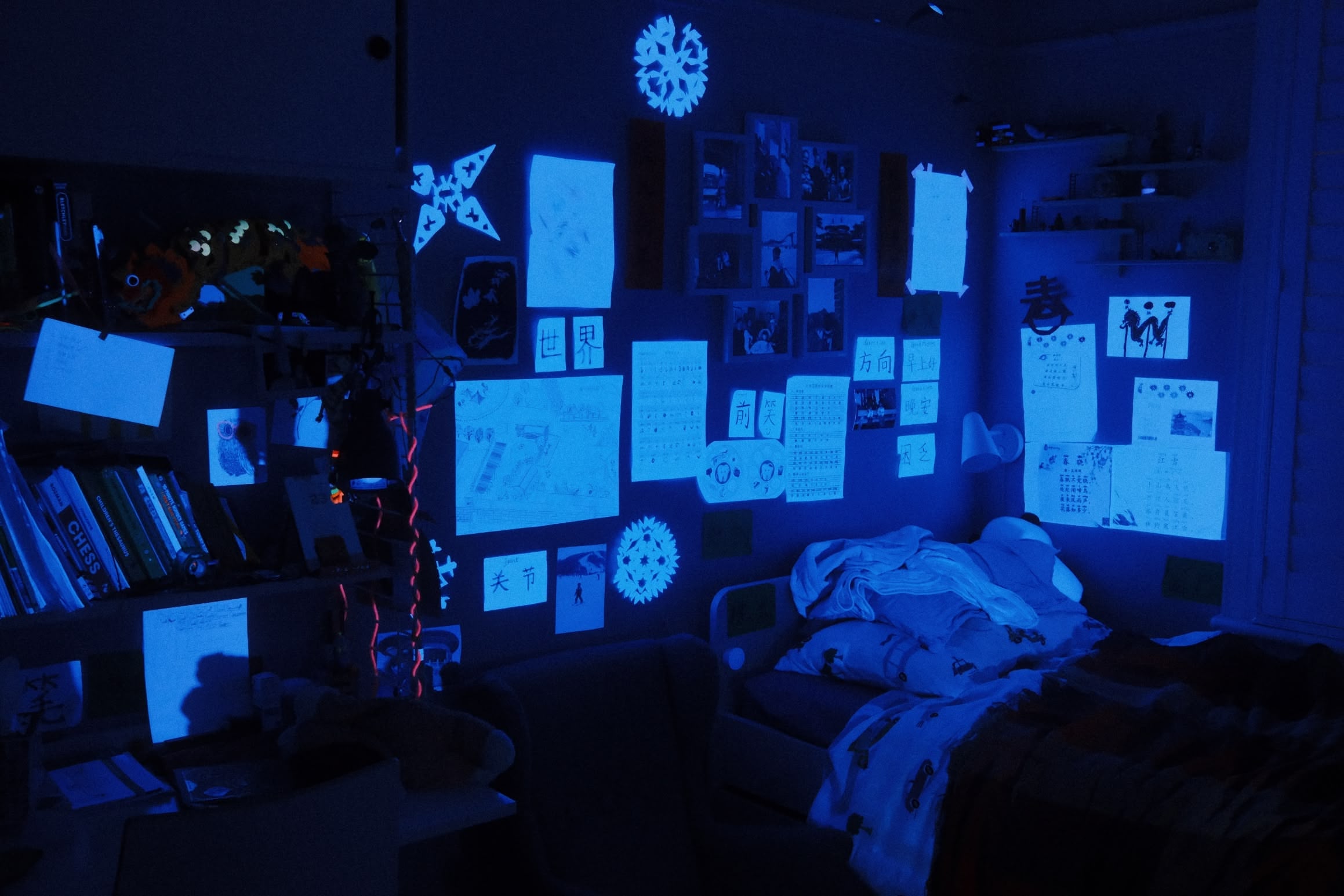 A child's bedroom. Many of the things stuck to the wall glow when lit with UV light.