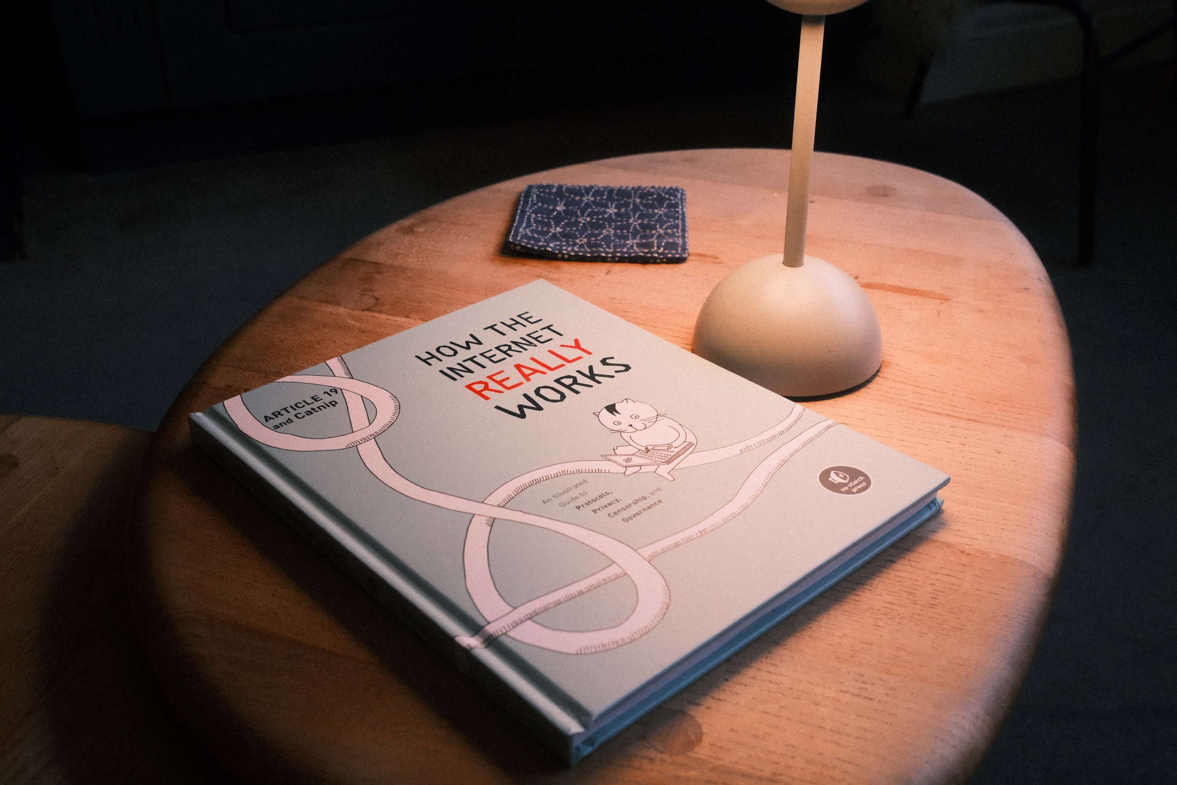 A book on a coffee table. The title of the book is, 'How the internet really works'