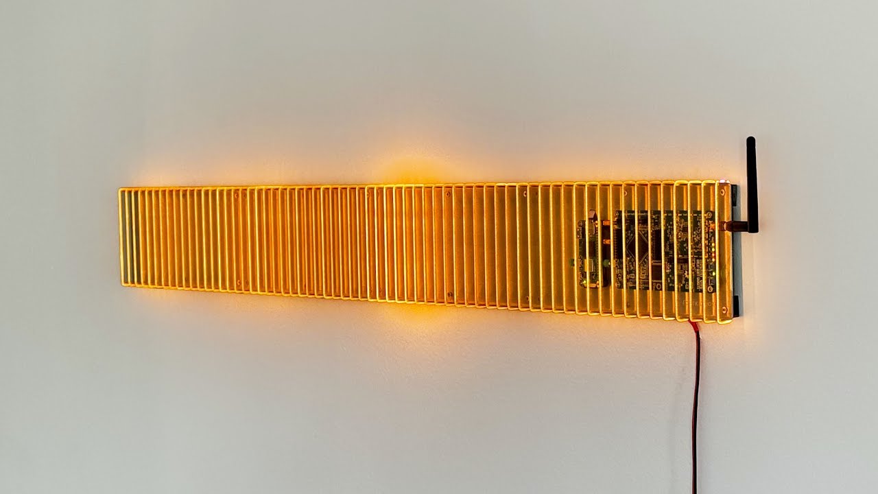 A long rectangular wall mounted light made up of thin LED filament wrapped around a frame.
