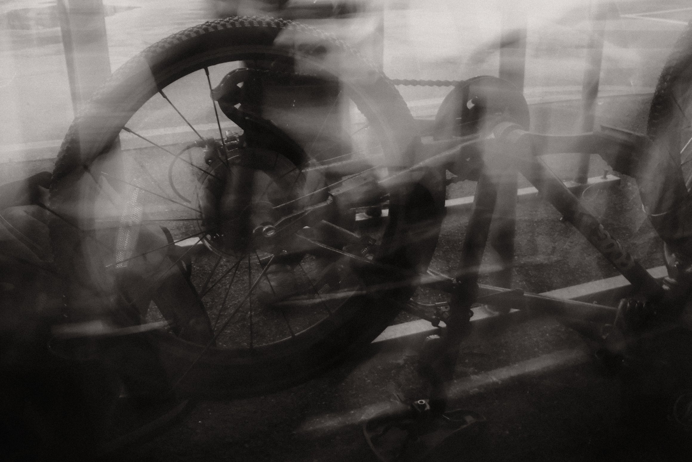 A black and white photo of a bike resting on its seat. The image is blurred as if taken in low light.