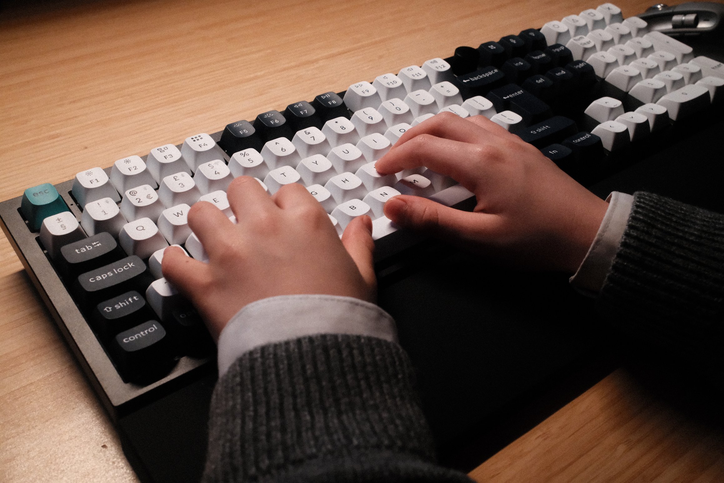 The hands of a child rest on a computer keyboard