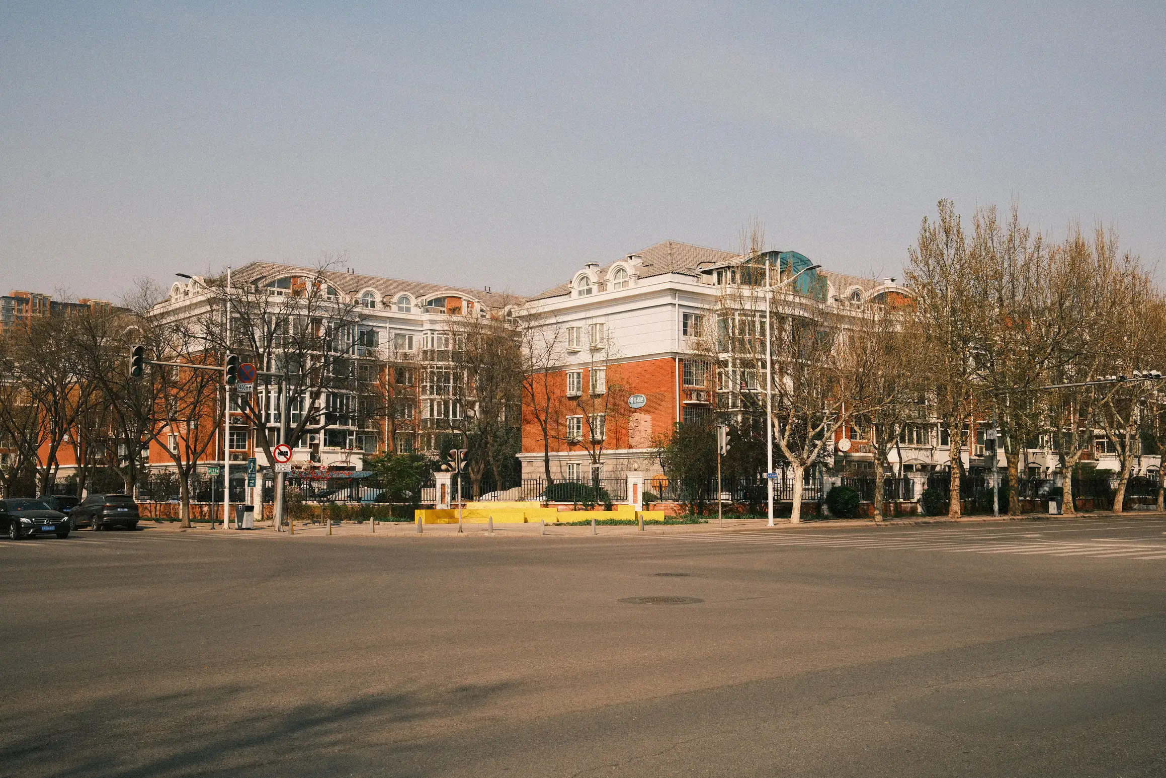 an expansive cross roads, free from traffic, looking over to residential compound