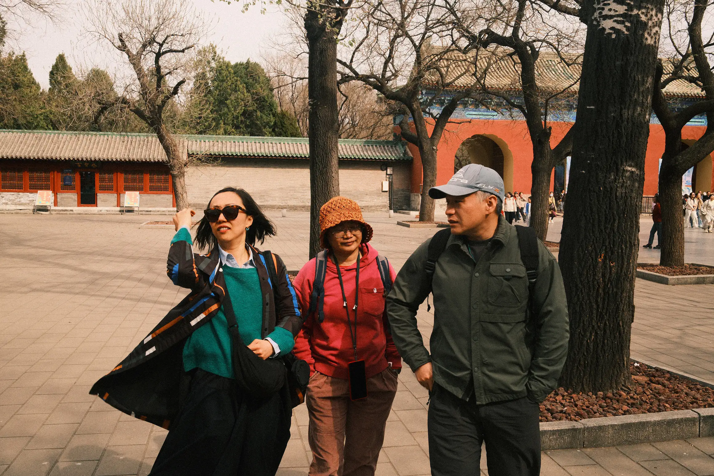 three people walking along talkig in the temple of heaven