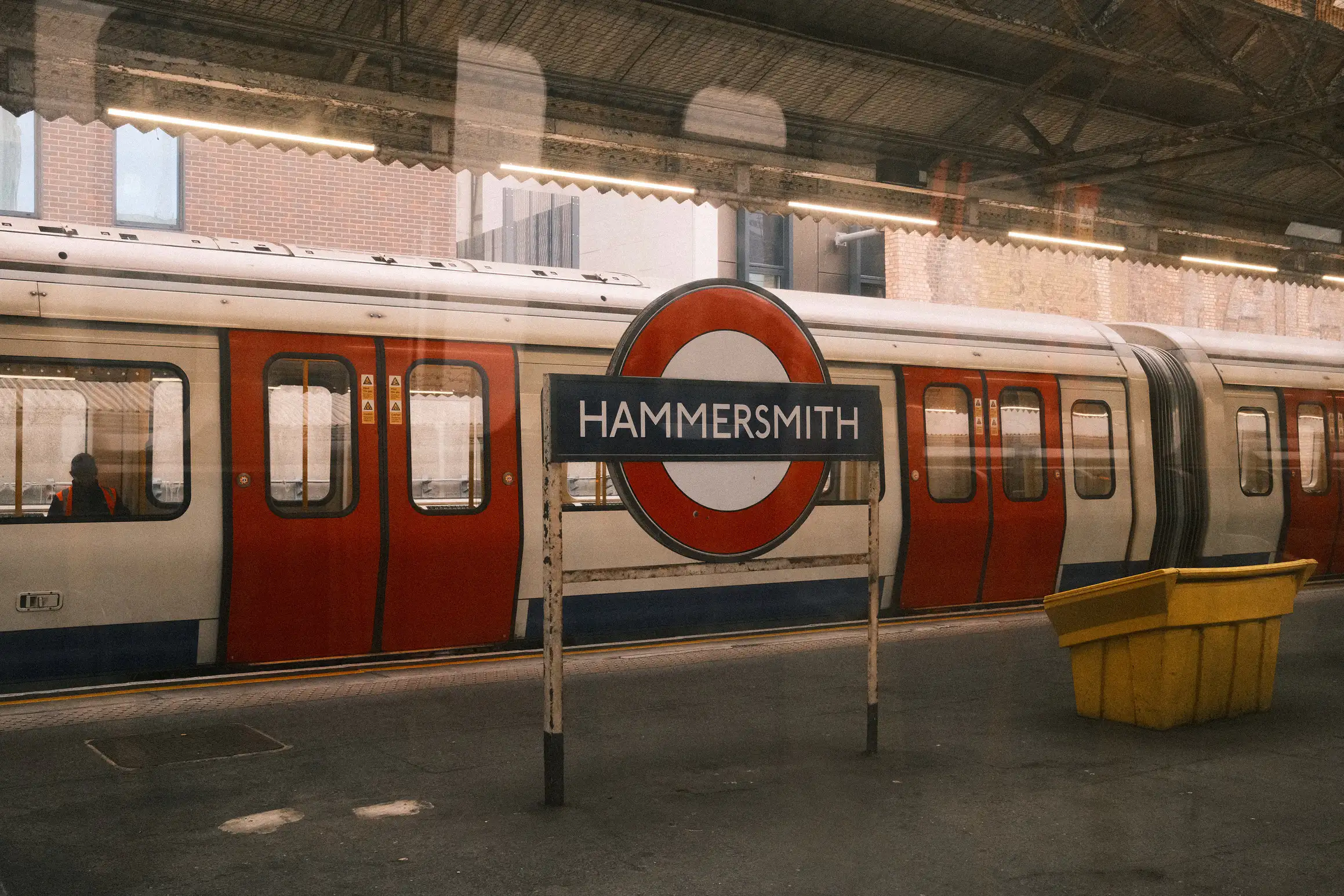 a photo of a hammersmith and city line train standing on the platform at hammersmith