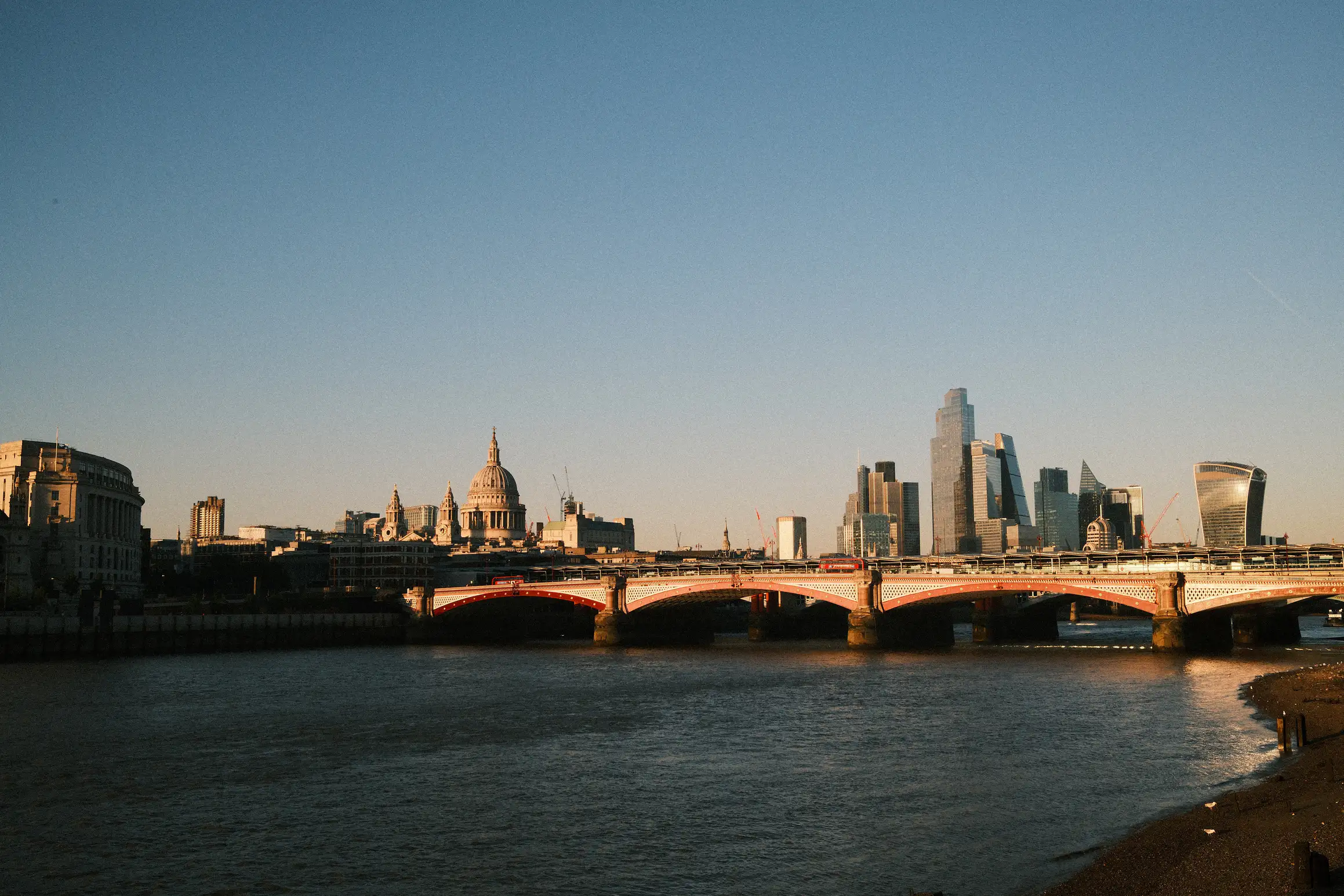 a late afternoon view across the London skyline, looking back over London Blackfriars station, skyscrapers and St Paul's catherdral stand out in the sun