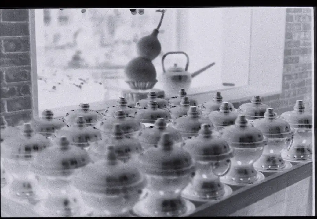 a photo of a negative showing a table covered in urns