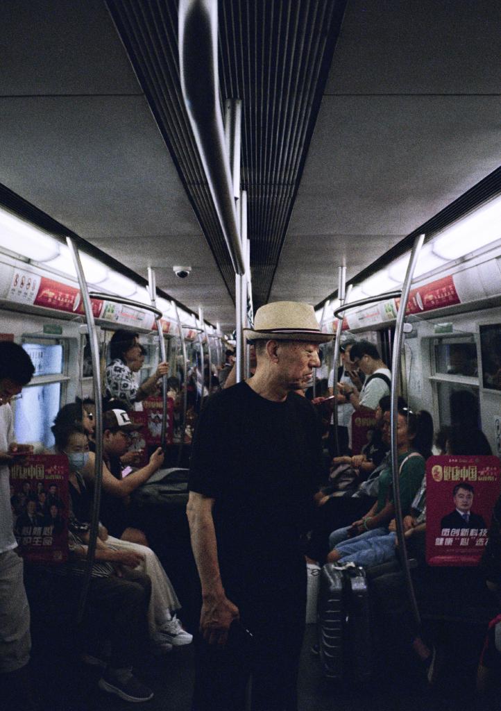 A man stands in the middles of a subway car on Line 4 in Beijing.