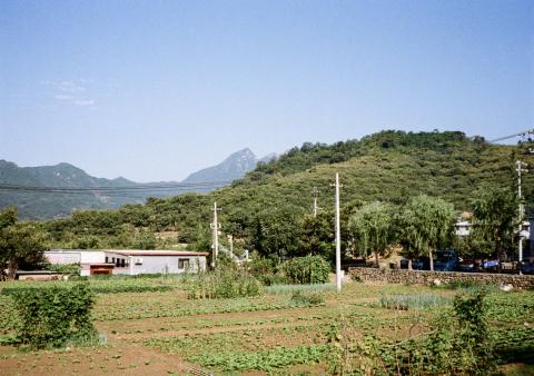 A view looking out over a rural farm to the mountains in the North of Beijing.